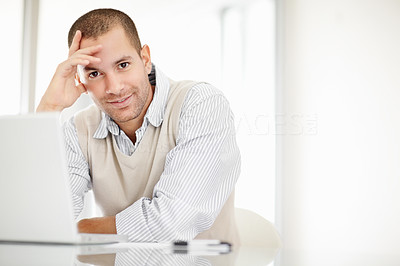 Relaxed middle aged man with a laptop on his desk