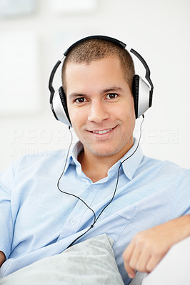 Relaxed middle aged man listening music through headphones