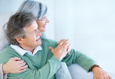 Old couple holding hands and looking away in thought