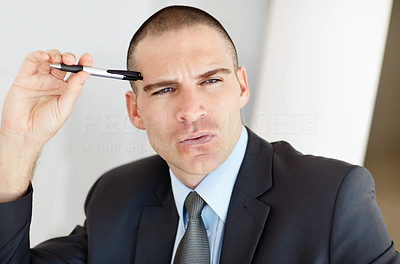Thoughtful middle aged business man holding a pen