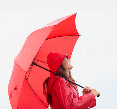 Cute teenage girl in a red raincoat with an umbrella outdoors
