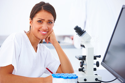 Happy teenage female researcher using microscope