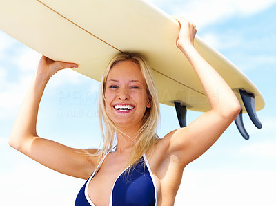 Happy young woman with surfboard on head