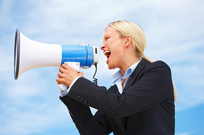 Business woman shouting through megaphone