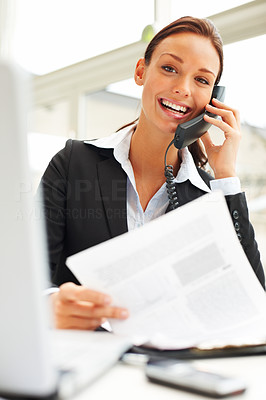 Confident businesswoman in black suit speaking to someone on the phone
