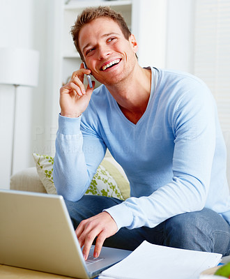 Laughing man using a computer laptop and mobile phone