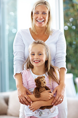 Young mother with her cute daughter holding teddy bear