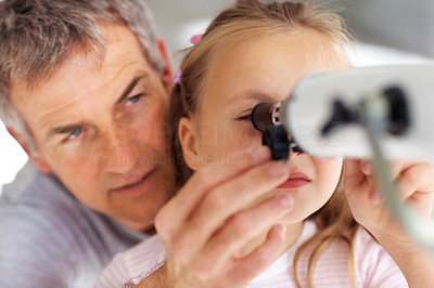 Mature father helping her daughter to look through telescope