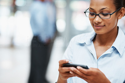 Black business woman text messaging on cell phone
