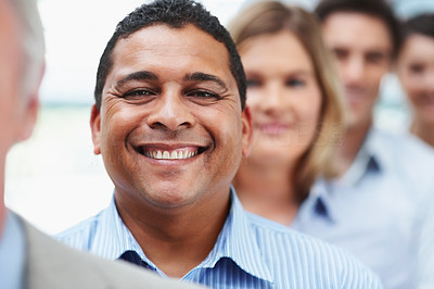 Smiling mixed race business man in line with colleagues