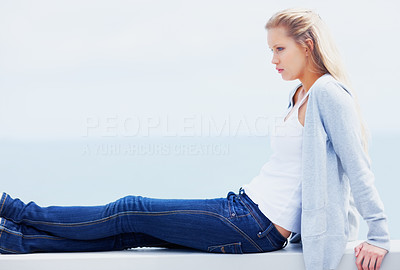 Young woman sitting in thought with copyspace