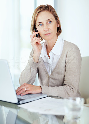 Middle aged businesswoman thinking while talking on mobile