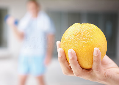 Closeup of a human hand holding an orange