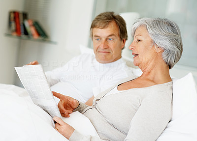 Relaxed couple spending time reading magazine together