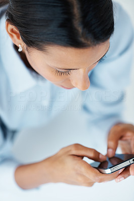 Female executive texting on mobile phone