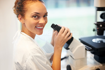 Female scientist analysis a sample in a microscope