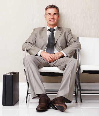 Happy business man sitting on chair in an office lounge
