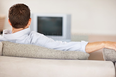 Middle aged man sitting in sofa while watching television