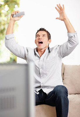 Cheerful middle aged man looking up while watching television