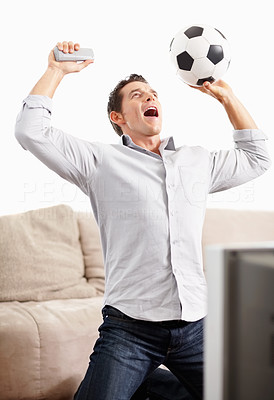 Joyful middle aged man watching football match on television