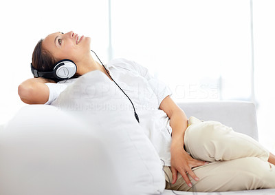 Relaxed woman listening to music while sitting at home