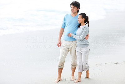 An affectionate couple walking on the sea shore