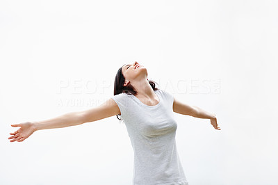 Relaxed young woman with arms outstretched on white background