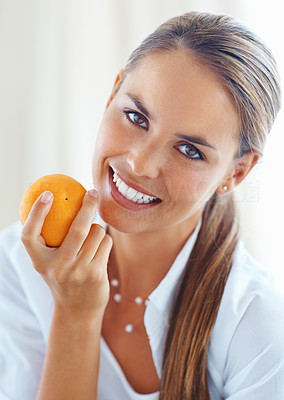 Healthy woman smiling with orange