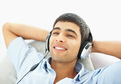 Portrait of a relaxed young guy enjoying music with copyspace