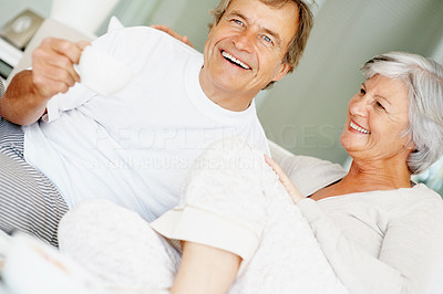 Loving and happy couple drinking coffee while in bed