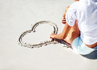 Drawing her heart in the sand