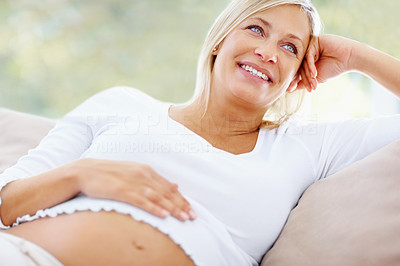Thoughtful middle aged pregnant woman at home