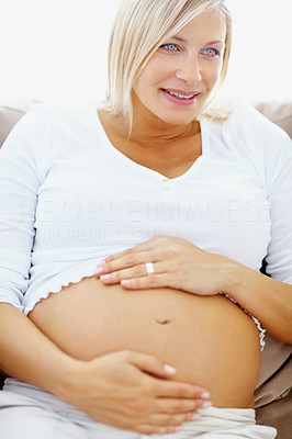 Happy pregnant woman holding her tummy at home