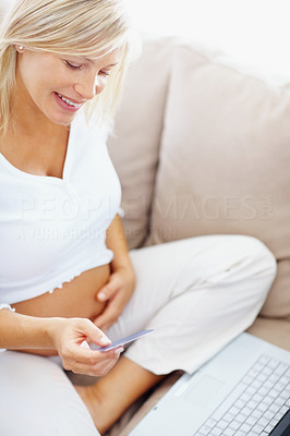 Pregnant woman shopping from the internet with her credit card