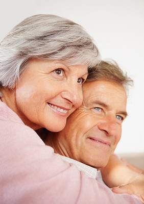 Closeup of a smiling older woman with arms around a man