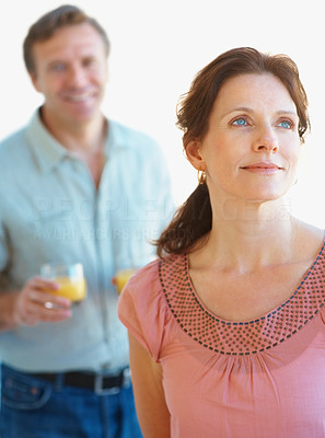 Mature woman deep in thought with a man in background