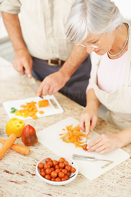 Older couple cutting vegetables together in the kitchen
