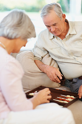 An old couple playing a game of backgammon