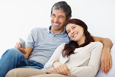 Mature couple watching television on white background