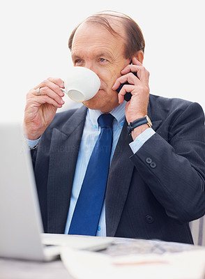 Business man with laptop on the phone while drinking