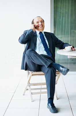 Senior business man using his cell phone during office break