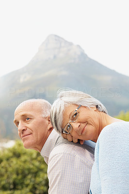 Romantic senior couple sitting against nature background