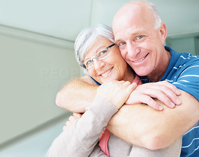 Romantic elderly man embracing his happy wife from behind