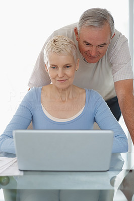 Smiling older man and woman using a laptop