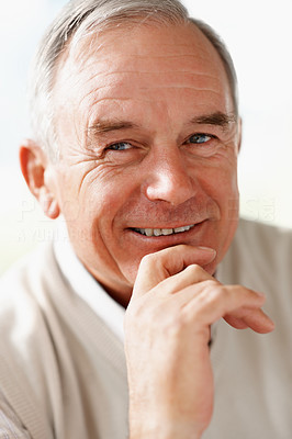 Closeup of a senior man with hand on chin smiling