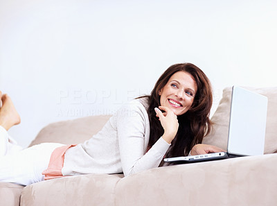 Pretty mature woman with a laptop on couch