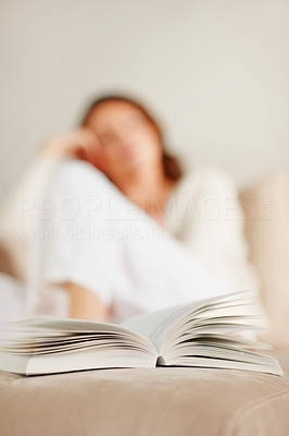 Closeup of open book with woman in background