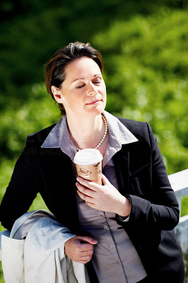 Woman with a disposable coffee cup at the park