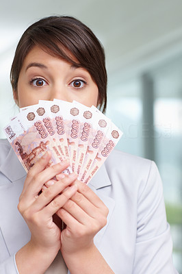 Woman with a fan of currency notes over her face