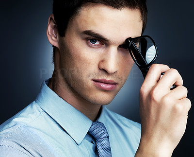 Thoughtful young business man holding glasses
